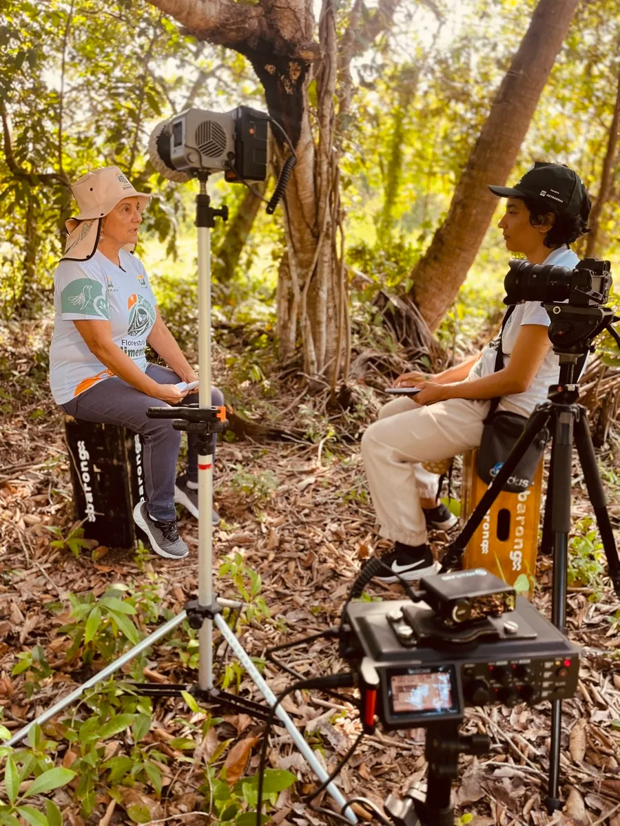 Entrevista sendo gravada em meio à mata, com dois operadores