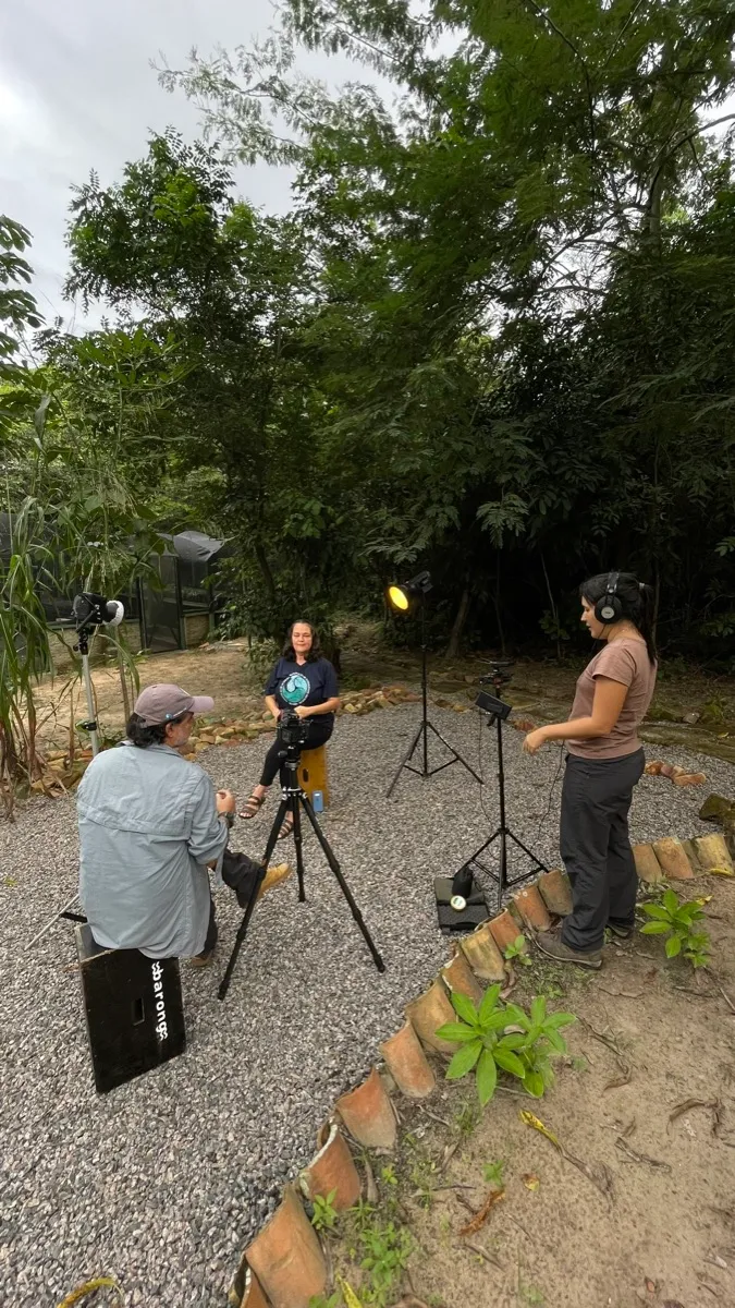 Equipe montando o set ao anoitecer, com iluminação artificial